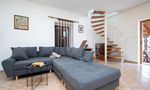 ein Wohnzimmer mit einem blauen Sofa und einer Treppe in der Unterkunft Apartment Tea in Preko