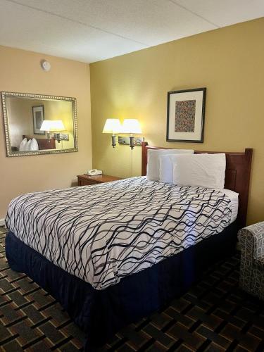 a hotel room with a bed and a mirror at West Bank Inn in Augusta