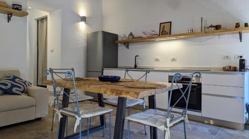ラ・マッダレーナにあるResidence Cala Francese - Case sul mareのキッチン(木製テーブル、椅子付)