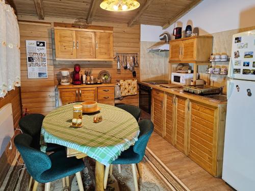 a kitchen with a table and chairs and a refrigerator at WHITE HOUSE, Vidraru in Căpăţîneni-Pămînteni