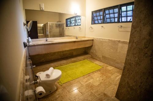 a bathroom with a tub and a toilet and a yellow rug at Paineiras Hotel Fazenda in Uberaba