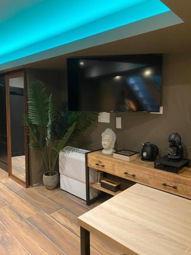 un salon avec une grande télévision à écran plat dans l'établissement A la Belle Étoile, le spa détente céleste, à Loison-sous-Lens