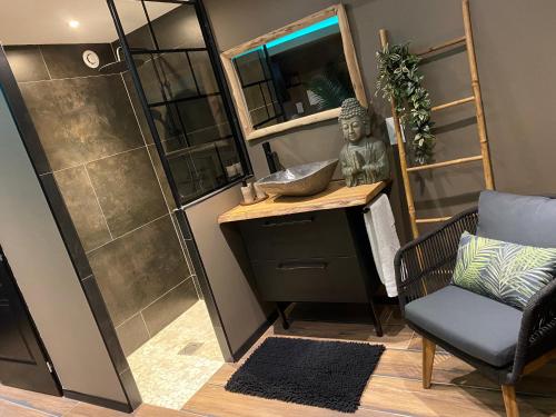 a bathroom with a shower and a desk and a chair at A la Belle Étoile, le spa détente céleste in Loison-sous-Lens