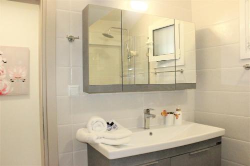 a white bathroom with a sink and a mirror at G&K House Garden in Messini