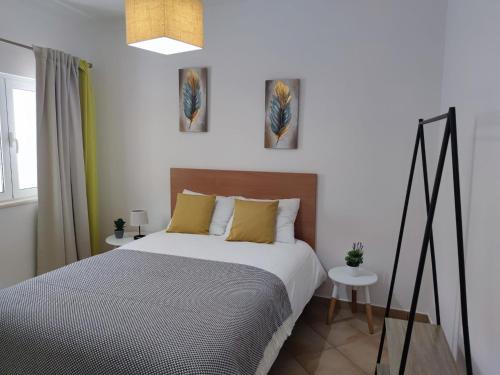 a bedroom with a bed and two paintings on the wall at Casas de Santo António in Odeceixe