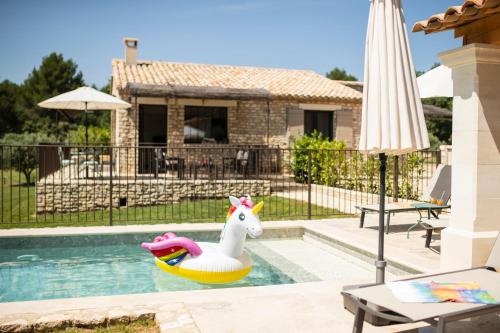 a pool with a unicorn float in a swimming pool at Bastide Toujours Dimanche, Maison de vacances avec vue & piscine privée in Gordes
