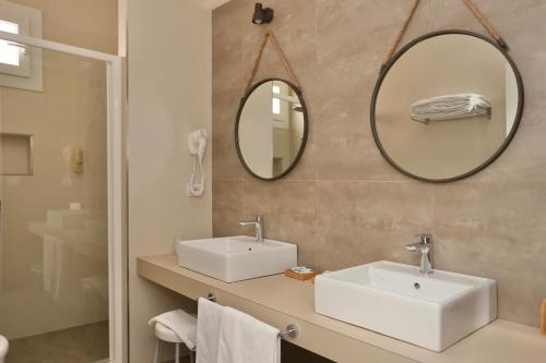 a bathroom with two sinks and a mirror at Hotel Flora in Cattolica