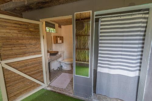 a bathroom with a toilet and a sliding glass door at La Canasta in El Zonte