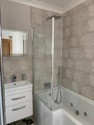 een badkamer met een douche, een bad en een wastafel bij Villa Levante in Paignton