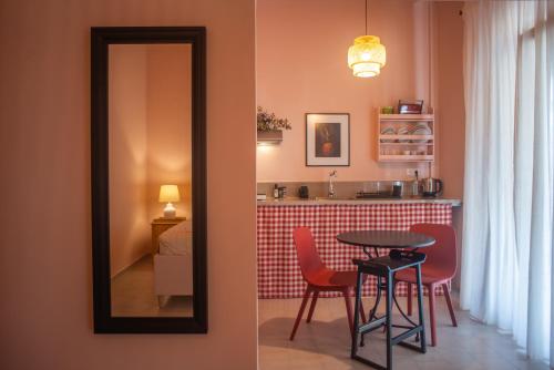 einen Spiegel sowie einen Tisch und Stühle in einem Zimmer in der Unterkunft Nina's apartment in Lixouri