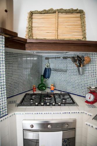 a kitchen with a stove and a tile wall at Nel cuore del centro storico di Maratea in Maratea