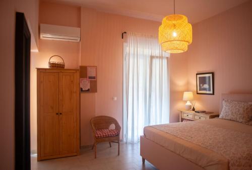 ein Schlafzimmer mit einem Bett, einem Stuhl und einem Fenster in der Unterkunft Nina's apartment in Lixouri