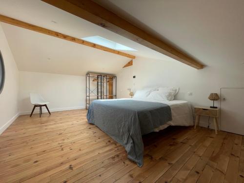 1 dormitorio con 1 cama y suelo de madera en Villa Manita, en Capbreton