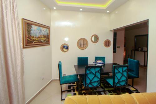 - une salle à manger avec une table et des chaises dans l'établissement Le "Grand Bleu", un bel appartement paisible, sûr et spatieux au cœur de la station balnéaire de Saly Portudal, à Saly Portudal