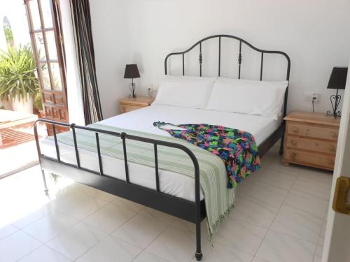 a bedroom with a bed with a black frame and white sheets at Las Palmeras del Cantal in Mojácar