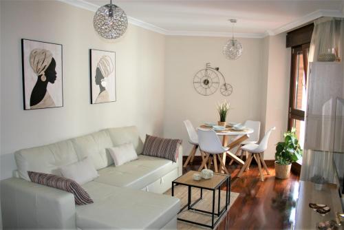 sala de estar con sofá blanco y mesa en El Fuste, en Oviedo