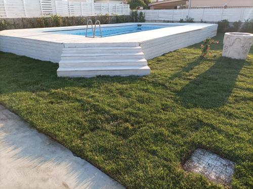 - une piscine dans l'herbe à côté d'une cour dans l'établissement Oasi del mare, à Granelli