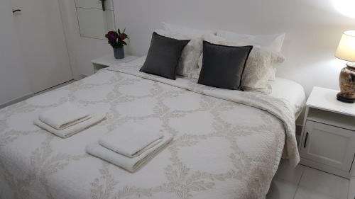 a bedroom with a white bed with towels on it at Apartments 101 in Kotor