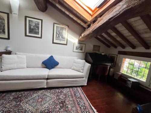 a living room with a white couch and a piano at A Casa Di Paola Suite in Ravenna