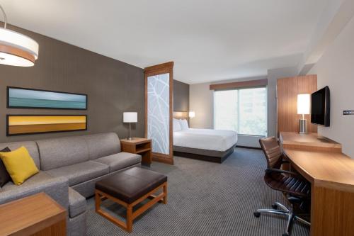 a hotel room with a couch and a bed at Hyatt Place San Jose Airport in San Jose