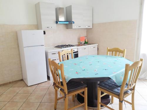 cocina con mesa, sillas y nevera en Levico Centrale Apartment en Levico Terme