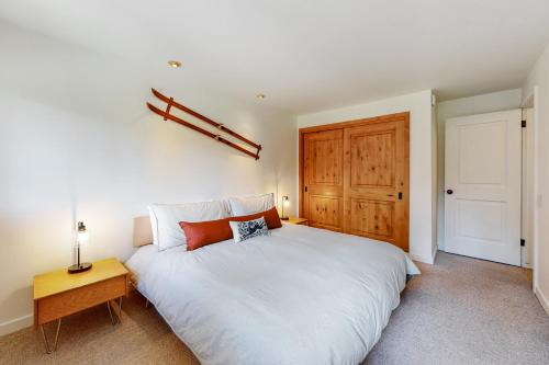 - une chambre avec un lit blanc et une porte en bois dans l'établissement Dollar Meadow 1385, à Sun Valley