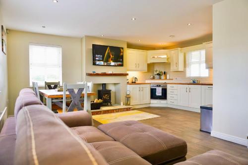 a large living room with a couch and a kitchen at Clonlum Holiday Cottages in Newry
