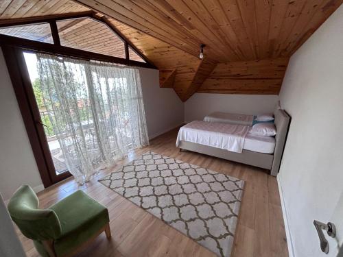 a bedroom with a bed and a chair and a window at Mimoza Park House in Trabzon