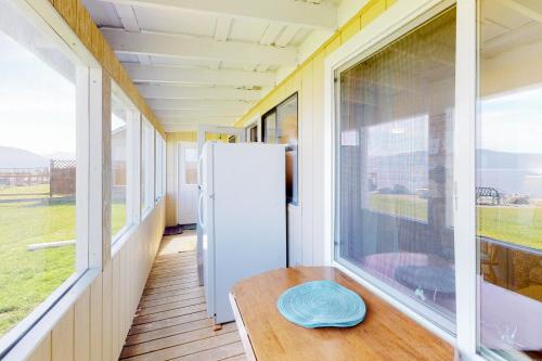 Zimmer mit einem Tisch und einem Kühlschrank auf dem Balkon in der Unterkunft Samish Bay Cottage in Bow