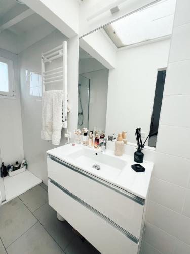 a white bathroom with a sink and a mirror at Apartamento Barcelona in Barcelona
