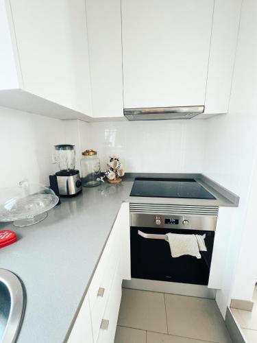 a white kitchen with a stove and a sink at Apartamento Barcelona in Barcelona