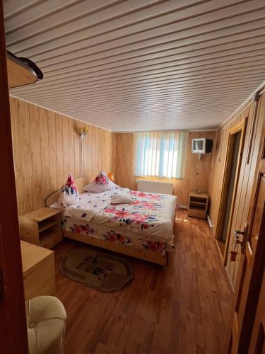 a bedroom with a bed and a wooden floor at Pensiunea Casa Ana in Agapia