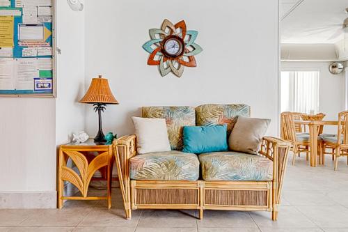 uma sala de estar com um sofá e uma mesa com um relógio em Beach Club #104 em Daytona Beach Shores