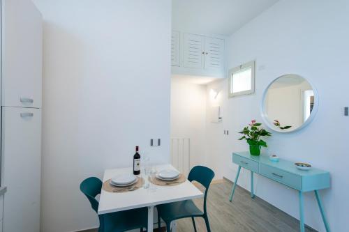 a dining room with a table and chairs and a mirror at Rays of sun - Positano in Positano