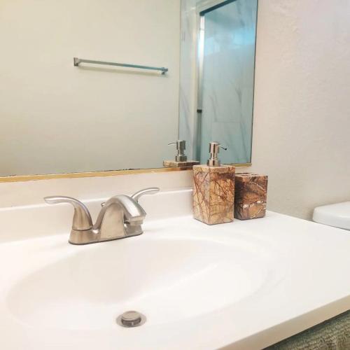 a bathroom sink with a mirror and a faucet at Nice Private Room in a House Close to Red Rock & Las Vegas Strip #1 in Las Vegas