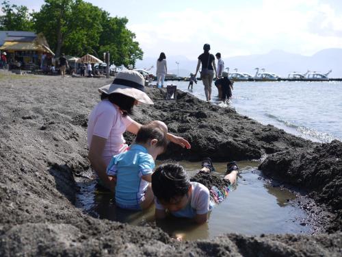 a group of people playing in the mud on the beach at KKR Kawayu in Teshikaga