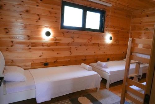 a log cabin with two beds and a window at Pirates Nest Cottages in Ulcinj