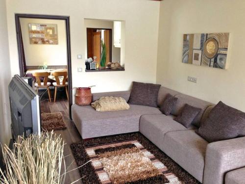 a living room with a couch and a tv at Cosy Apartment near Faaker See in Latschach
