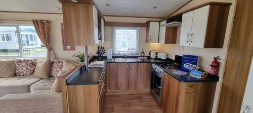 a small kitchen with a couch in a caravan at Golden Palm Resort - St David - Coastal Caravan Breaks in Chapel Saint Leonards