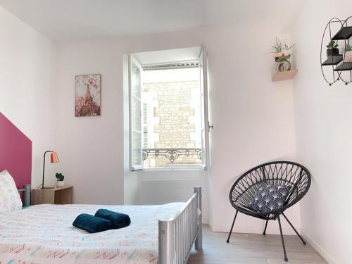 une chambre blanche avec un lit et une chaise dans l'établissement Jolie appartement 2 chambres 65m2 au centre ville, à Fontenay-le-Comte
