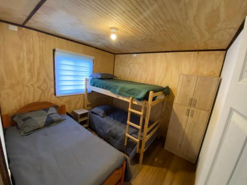 a small room with two bunk beds and a window at Cabañas Loma Alta in Osorno