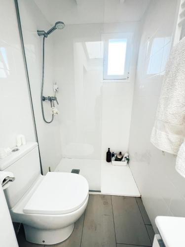 a white bathroom with a toilet and a shower at Apartamento Barcelona in Barcelona