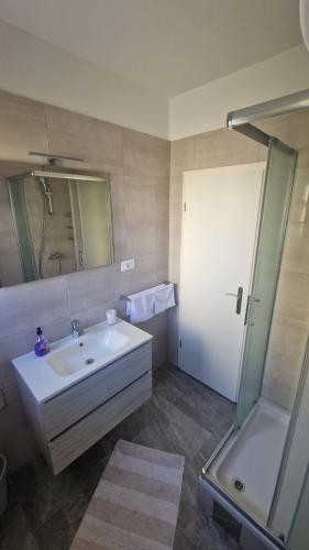 a bathroom with a white sink and a shower at Miljenko&Miljenka in Supetarska Draga