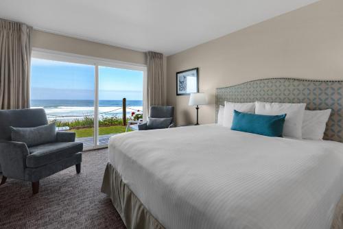 a hotel room with a bed and a large window at Pelican Shores Inn in Lincoln City