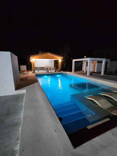 a large blue swimming pool at night at Pergola´s Road House in Yalsí