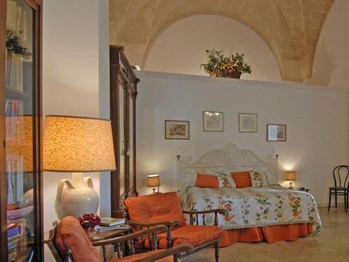 a bedroom with a bed and a table and a chair at B&b l'Orangerie D'epoque in Lecce