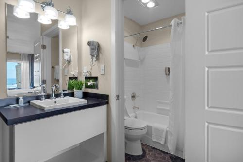 La salle de bains est pourvue d'un lavabo et de toilettes. dans l'établissement Pelican Shores Inn, à Lincoln City
