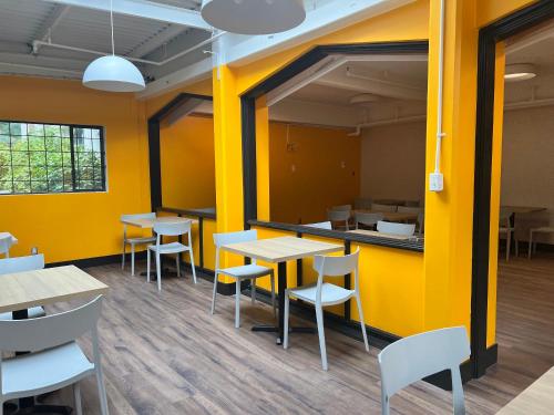 a restaurant with yellow walls and tables and chairs at HI Vancouver Downtown - Hostel in Vancouver