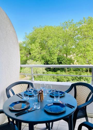 une table bleue avec des verres sur un balcon dans l'établissement Bienvenue chez Méli et Dorian, à La Grande Motte