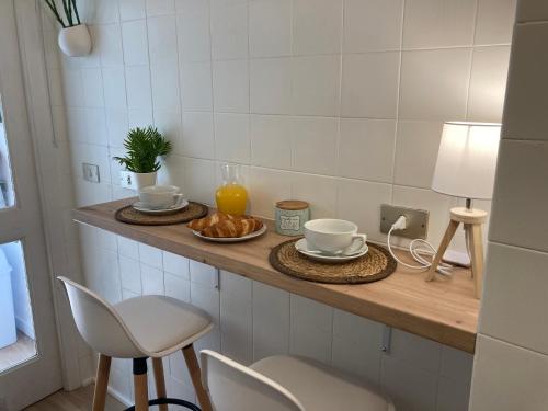 un mostrador con dos tazas y platos de comida. en Precioso piso en Baiona con vistas al mar, en Baiona